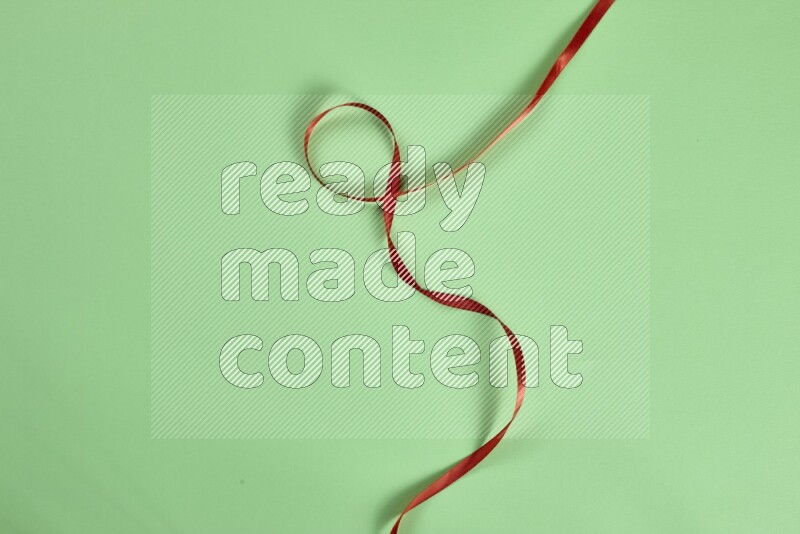 A red collection of sewing and tailoring tools arranged on a green background