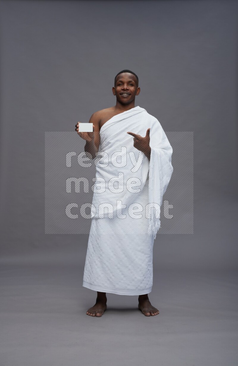 A man wearing Ehram Standing holding ATM card on gray background