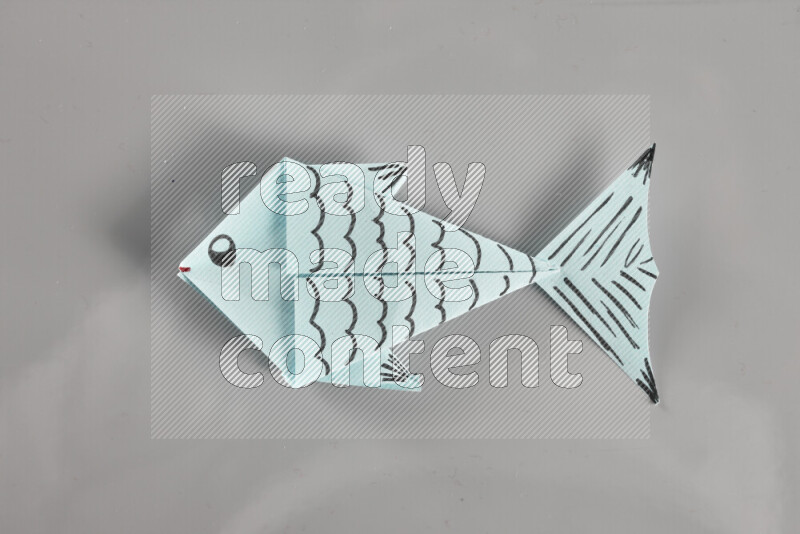 Origami fish on grey background