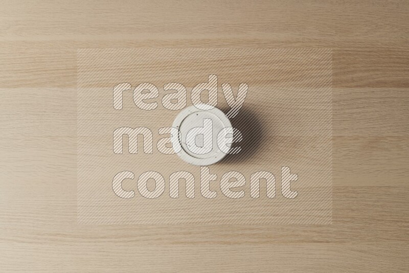 A white pottery bowl on light wooden background