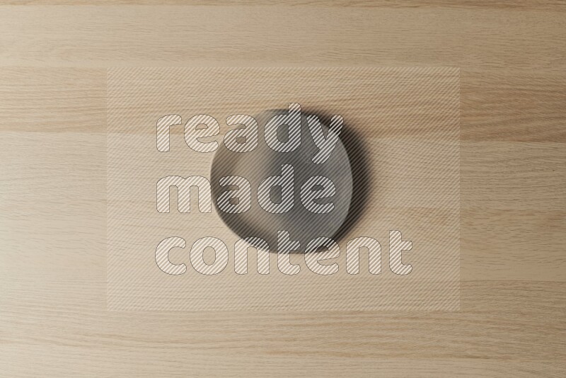 A multicolored pottery plate on light wooden background