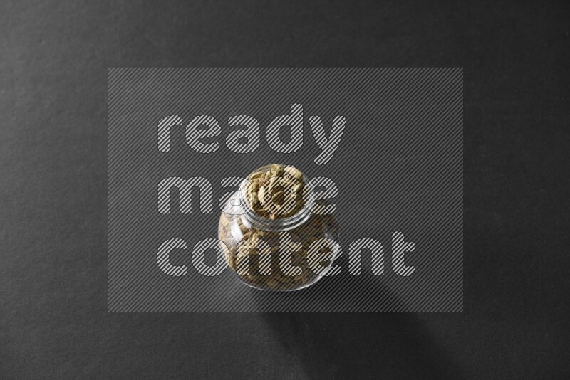 هيل في وعاء زجاجي علي خلفية سوداء