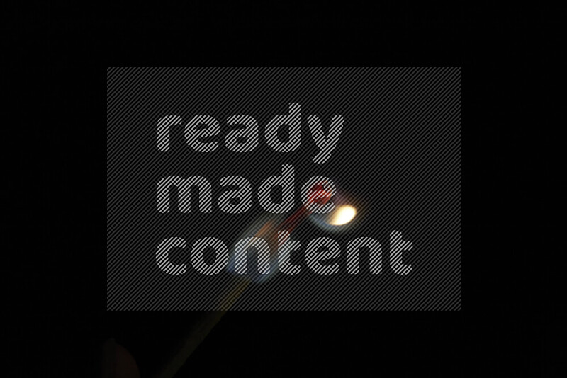 A burning matchstick isolated on dark backdrop