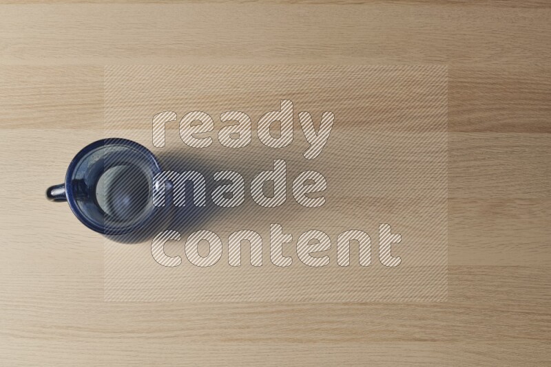 إبريق زجاجي فارغ على خلفية خشبية فاتحة