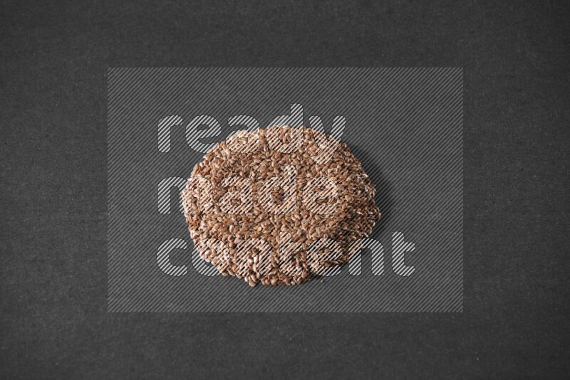 Flax Seeds in a circle shape on a black Flooring