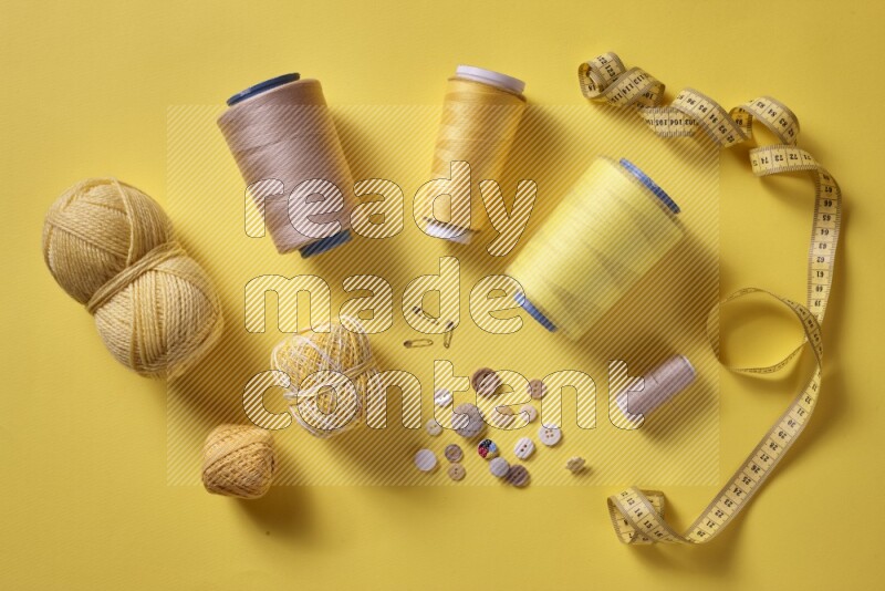 A yellow collection of sewing and tailoring tools arranged on a yellow background
