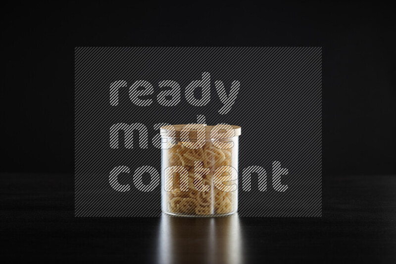 Snacks in a glass jar on black background