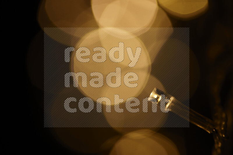 Light bulbs glowing against backdrop of golden bokeh