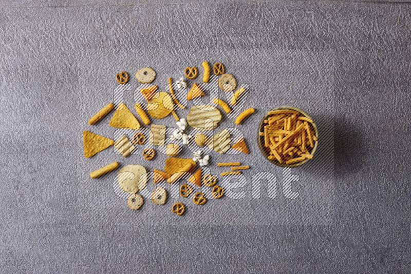 Assorted snacks in pottery bowls on grey background