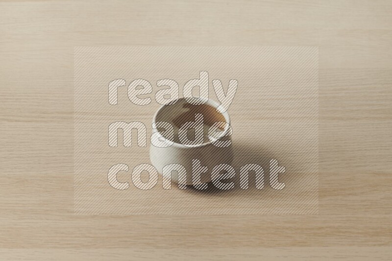 A multicolored pottery bowl on light wooden background