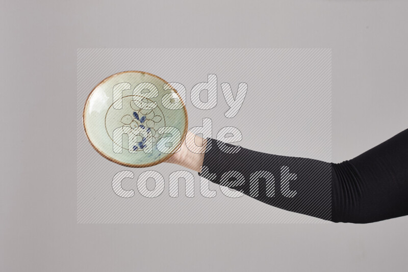 امرأة ترتدي عباءة سوداء تحمل أدوات فخارية مختلفة في أوضاع متعددة