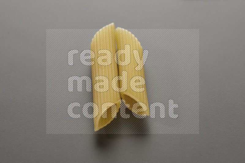 Penne pasta on grey background
