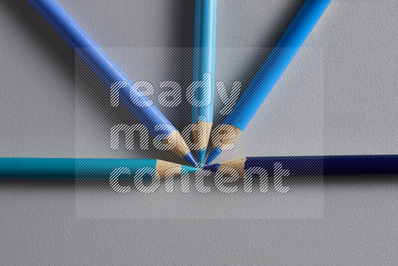 An arrangement of colored pencils in different colors on grey background