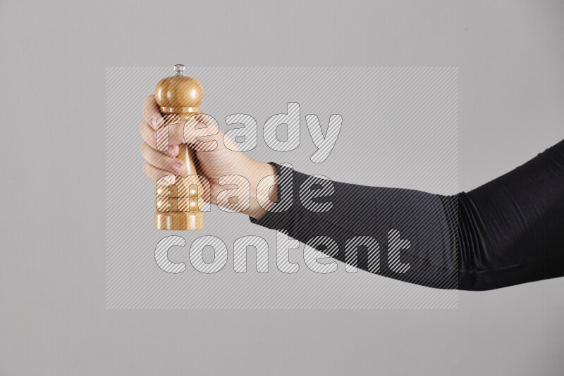 A woman in black abaya holding different wooden essentials in different positions