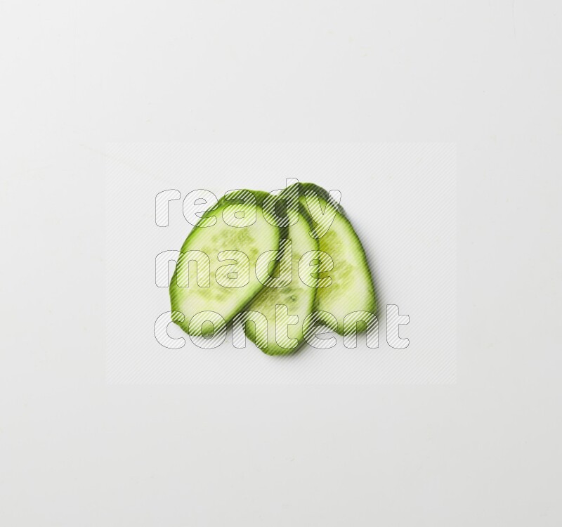 three cucumber slices on white background