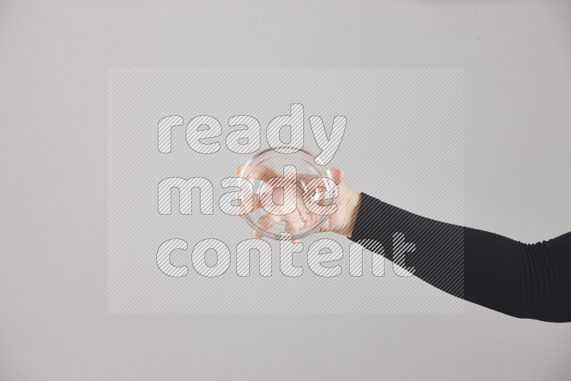 A woman in black abaya holding different glassware in different positions