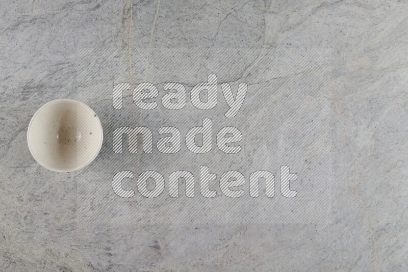 A white pottery bowl on grey marble background