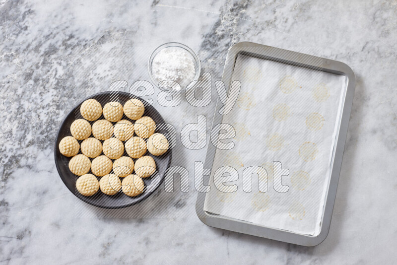 Kahk step by step with its ingredients ghee, sugar, flour, sesame, yeast, water and kahk flavor on grey marble background
