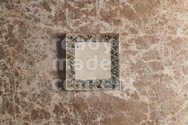 A decorative pottery plate on beige marble background