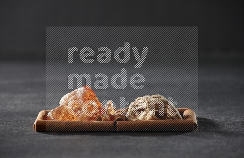 2 squares of cinnamon sticks full of dried ginger and gum arabic on black flooring