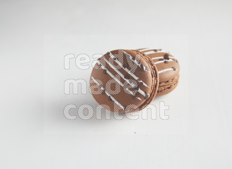 45º Shot of two Brown white Chocolate Caramel macarons on white background