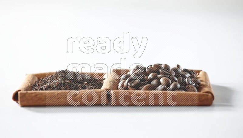 مربعان من أعواد القرفة ممتلئان بحبوب القهوة والشاي الأسود علي خلفية بيضاء