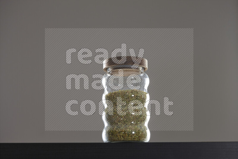 Freekeh in a glass jar on black background