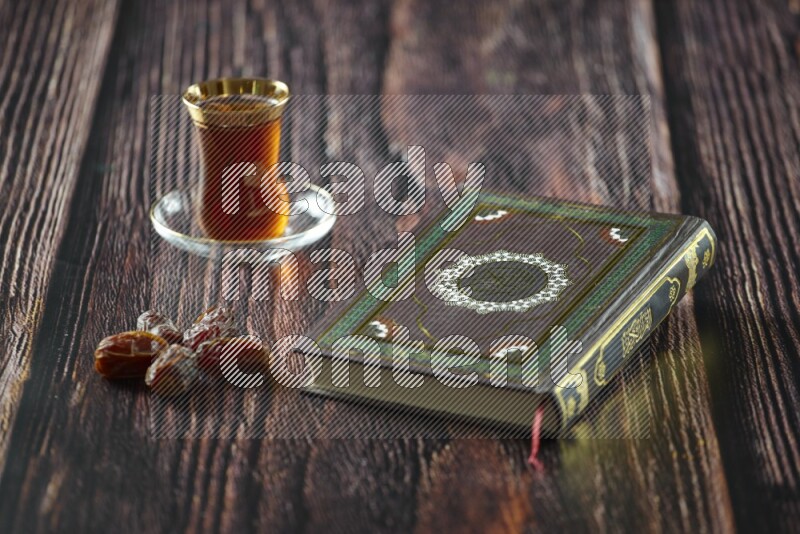 Quran with dates, prayer beads and different drinks all placed on wooden background