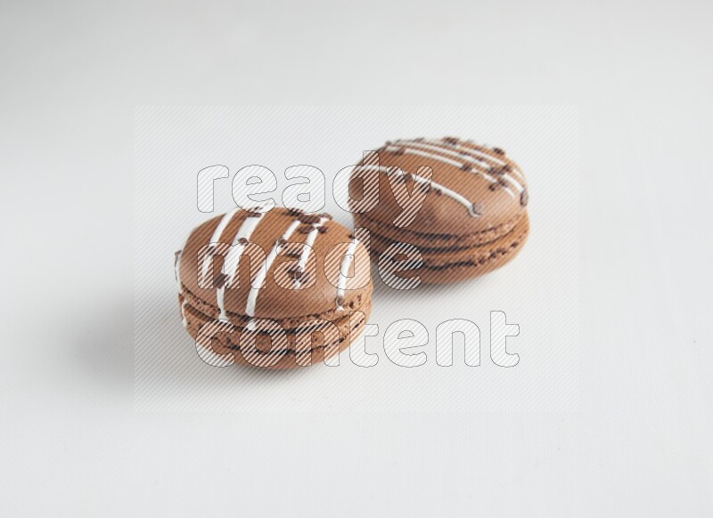45º Shot of two Brown white Chocolate Caramel macarons on white background