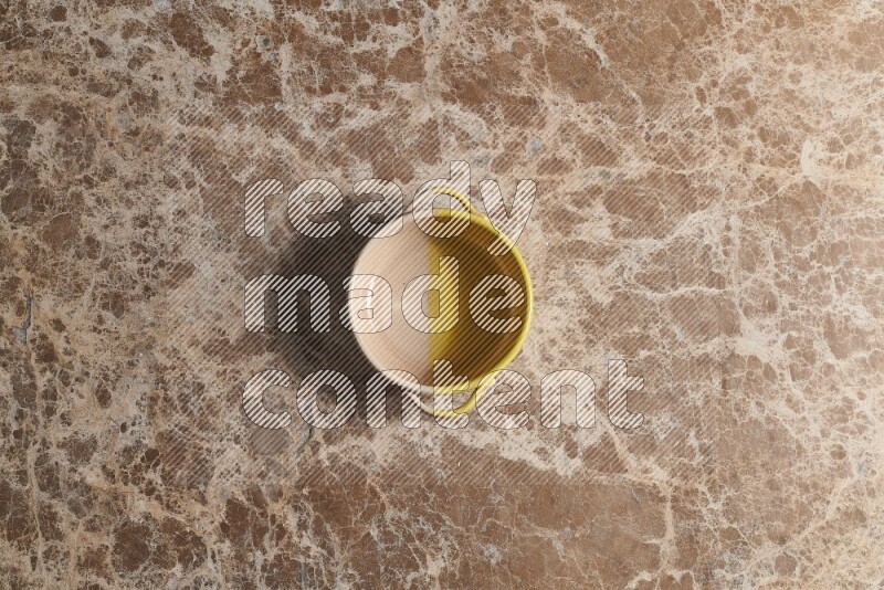 A multicolored pottery bowl on beige marble background