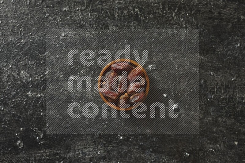 Dates in wooden bowls in a dark setup