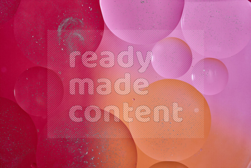 Close-ups of abstract oil bubbles on water surface in shades of red, orange and pink