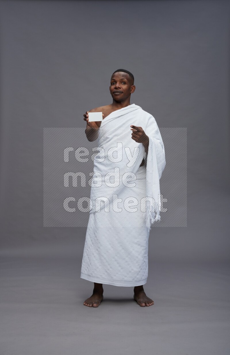 A man wearing Ehram Standing holding ATM card on gray background