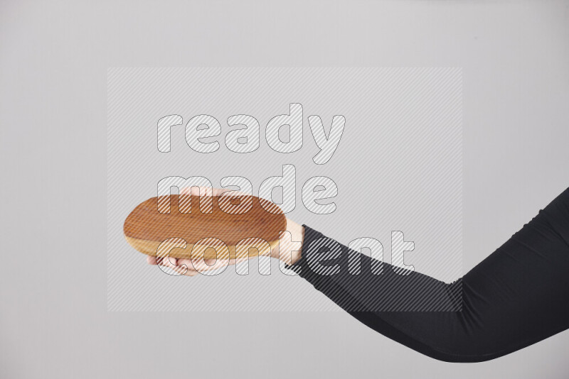 A woman in black abaya holding different wooden essentials in different positions