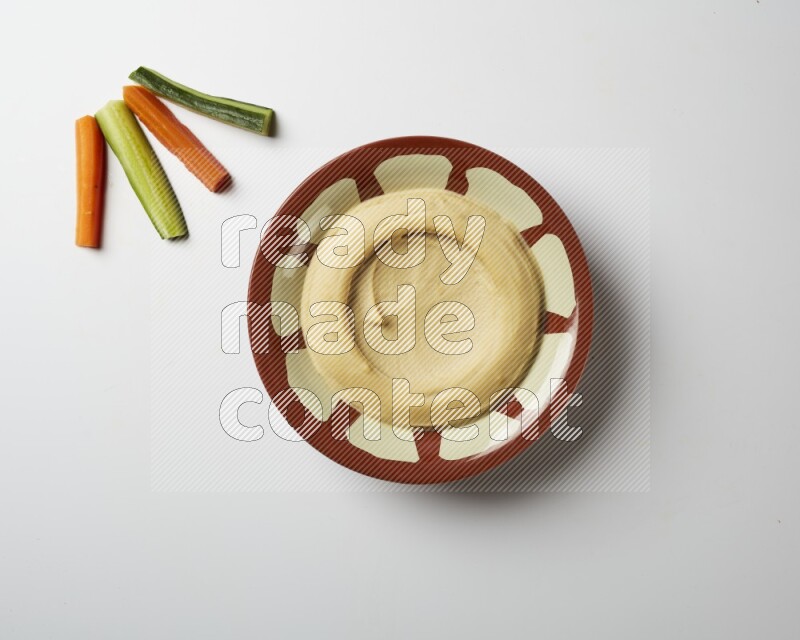 Plain hummus in a traditional plate on a white background