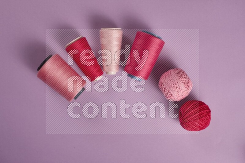 A pink and purple collection of sewing and tailoring tools arranged on a purple background