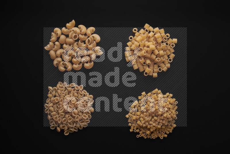 Different pasta types in bunches on black background