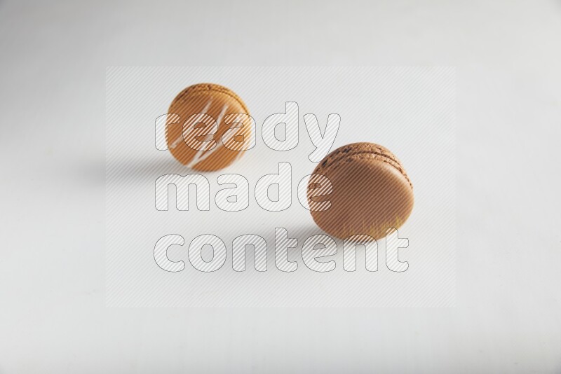 45º Shot of of two assorted Brown Irish Cream, and Brown Coffee macarons  on white background