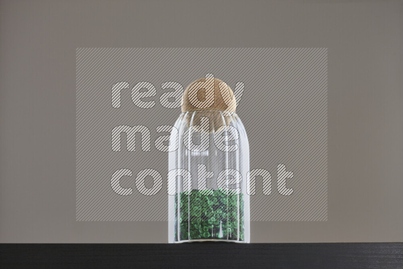 Sequins in a glass jar on black background