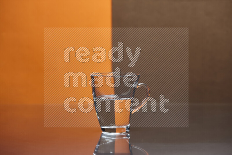 The image features a clear glassware filled with water, set against orange and brown background