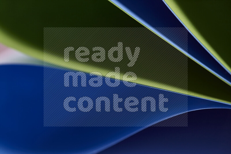 An abstract art showing blue and green paper sheets arranged in an overlapping curves