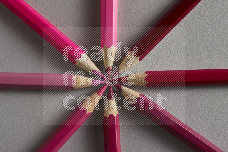 An arrangement of colored pencils in different colors on grey background