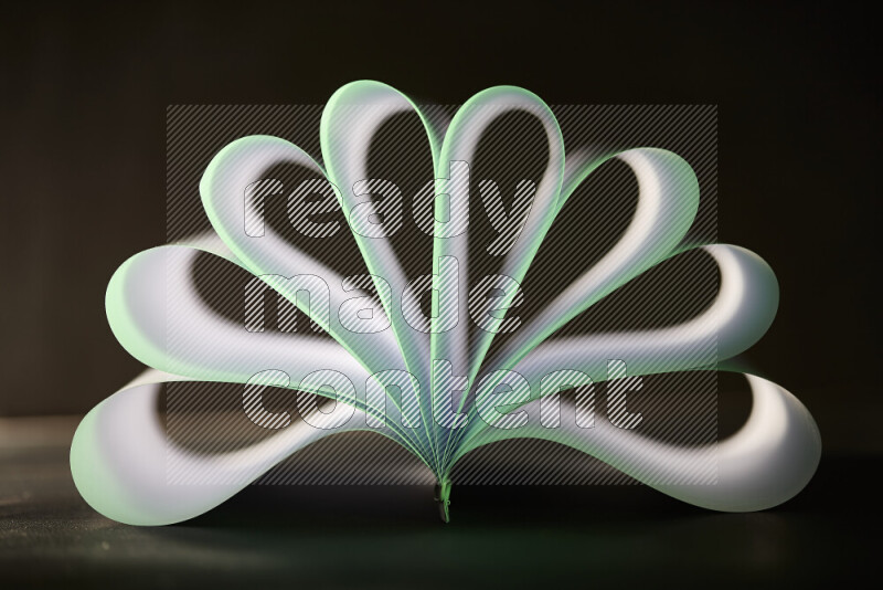 An abstract art piece displaying smooth curves in green and white gradients created by colored light