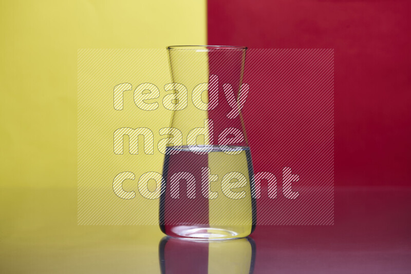 The image features a clear glassware filled with water, set against yellow and red background