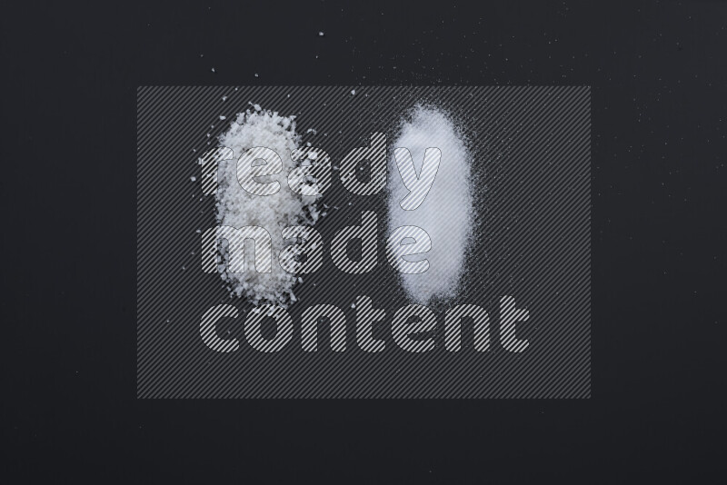 Bunches of table salt, coarse sea salt, fine himalayan salt and coarse himalayan salt on black background