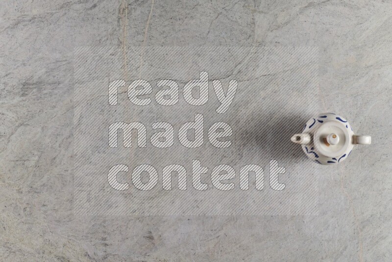 A pottery teapot on grey marble background