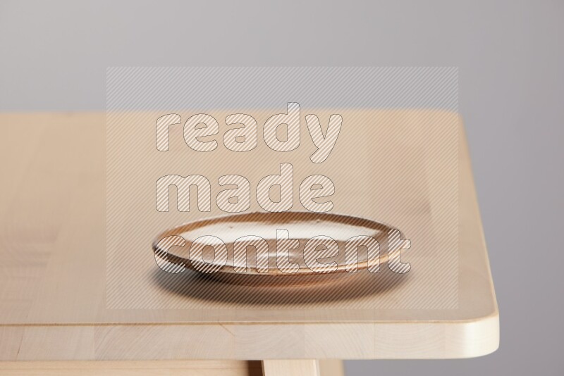 multi-colored pottery Plate on a wooden table edge