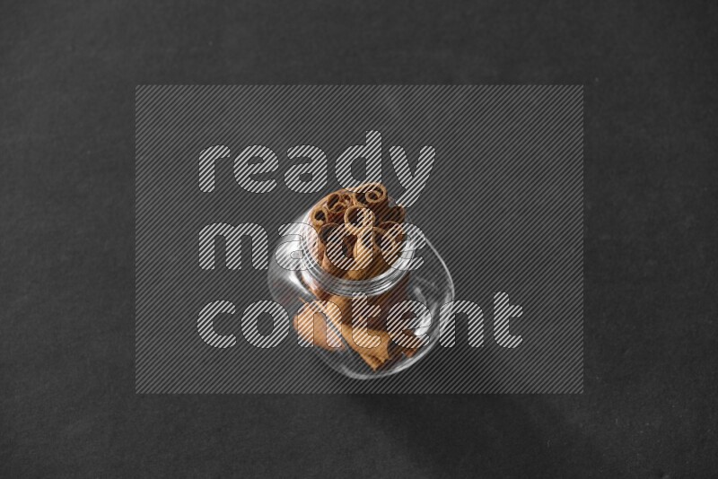 أعواد القرفة في وعاء زجاجي علي خلفية سوداء