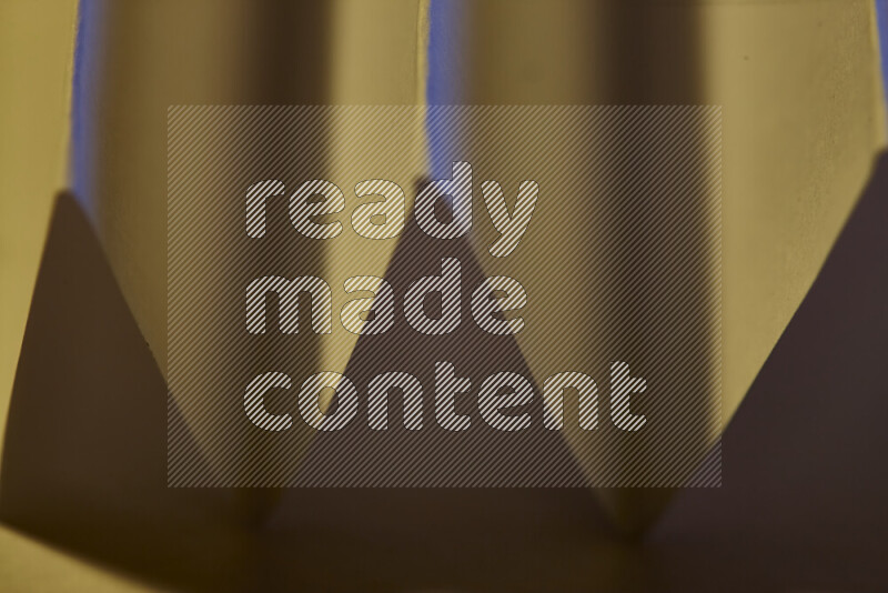 A close-up abstract image showing sharp geometric paper folds in warm gradients