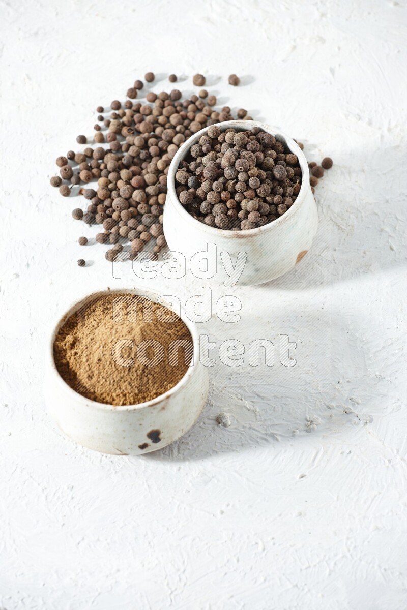 2 beige bowls, one full of powder and the other full of whole balls with balls and powder spreaded on a textured white flooring